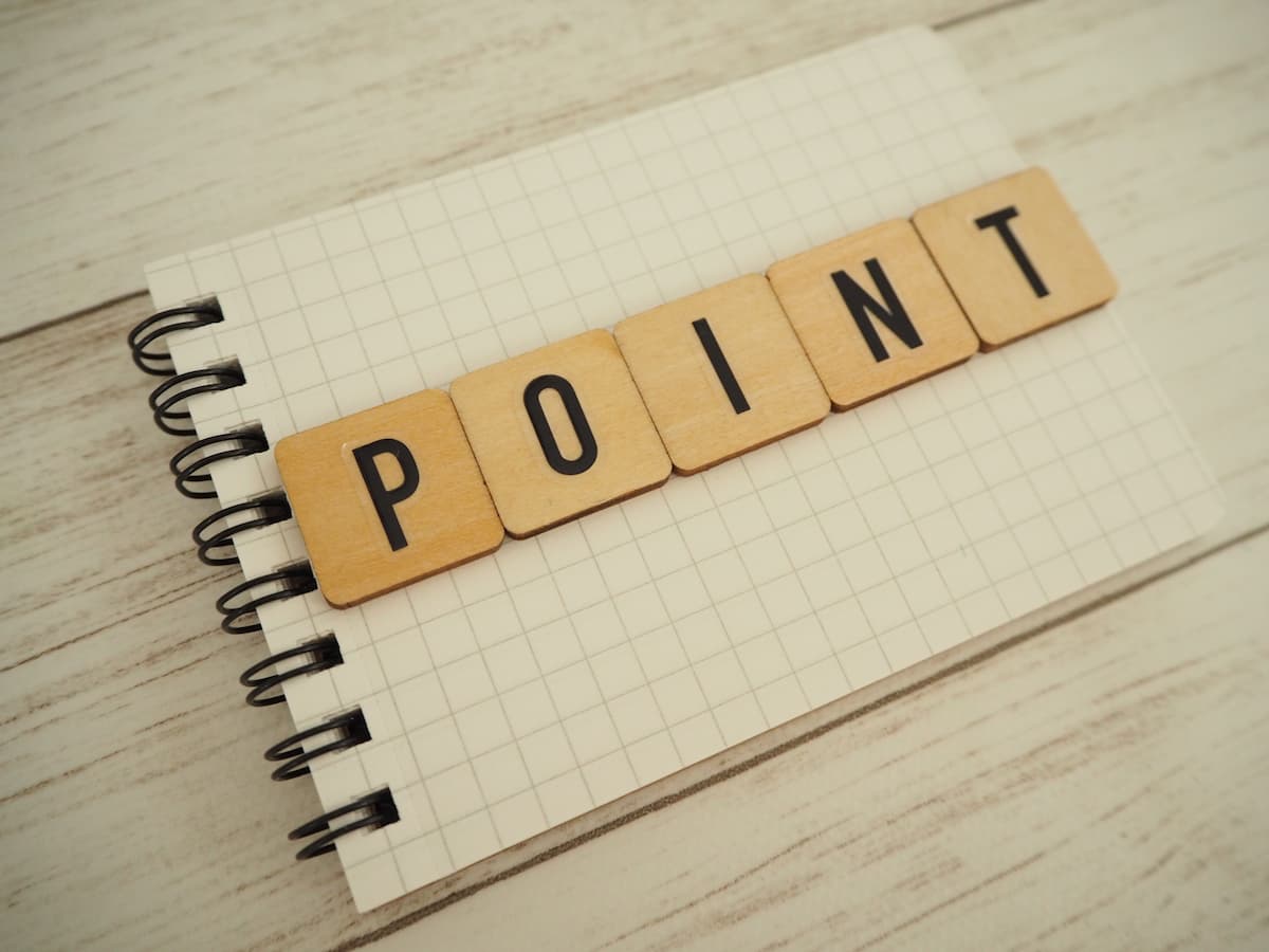 ノートの上に木製ブロックで「ポイント」の単語